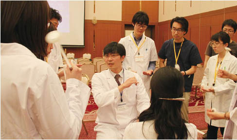神経診察のセッションでの一コマ.伊藤彰一先生から打腱器の持ち方を教わる．